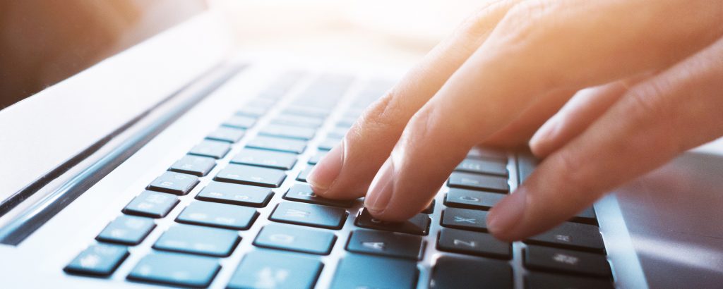 Hands typing on laptop computer